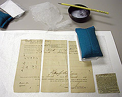 The conservators use wheat paste and handmade Japanese paper to mend tears.