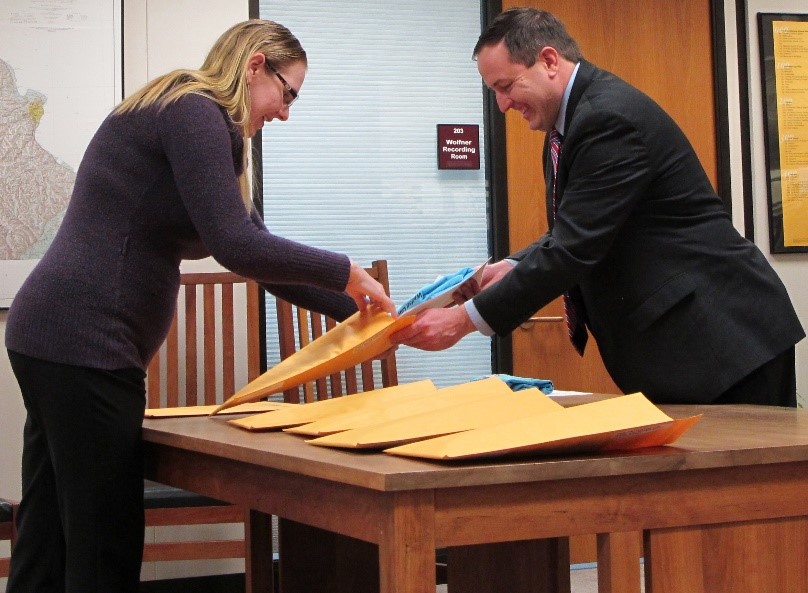 Secretary Ashcroft and Lisa Hellman packaging a graduate's kit.