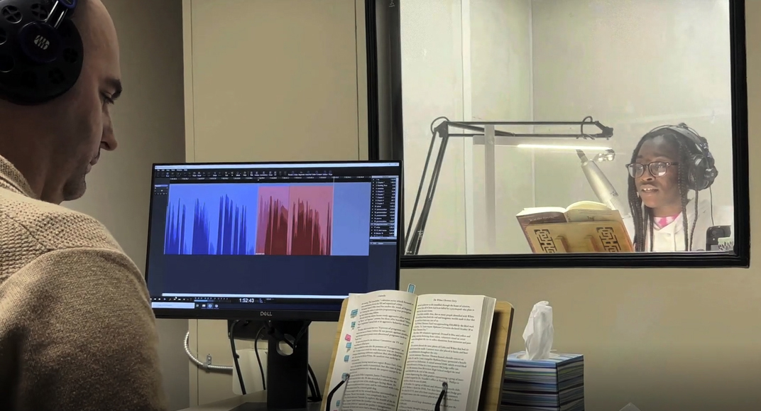 Monitor looking over narrator while recording a book narration