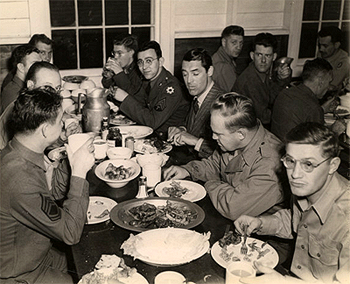 Cary Grant eating and drinking with the soldiers.